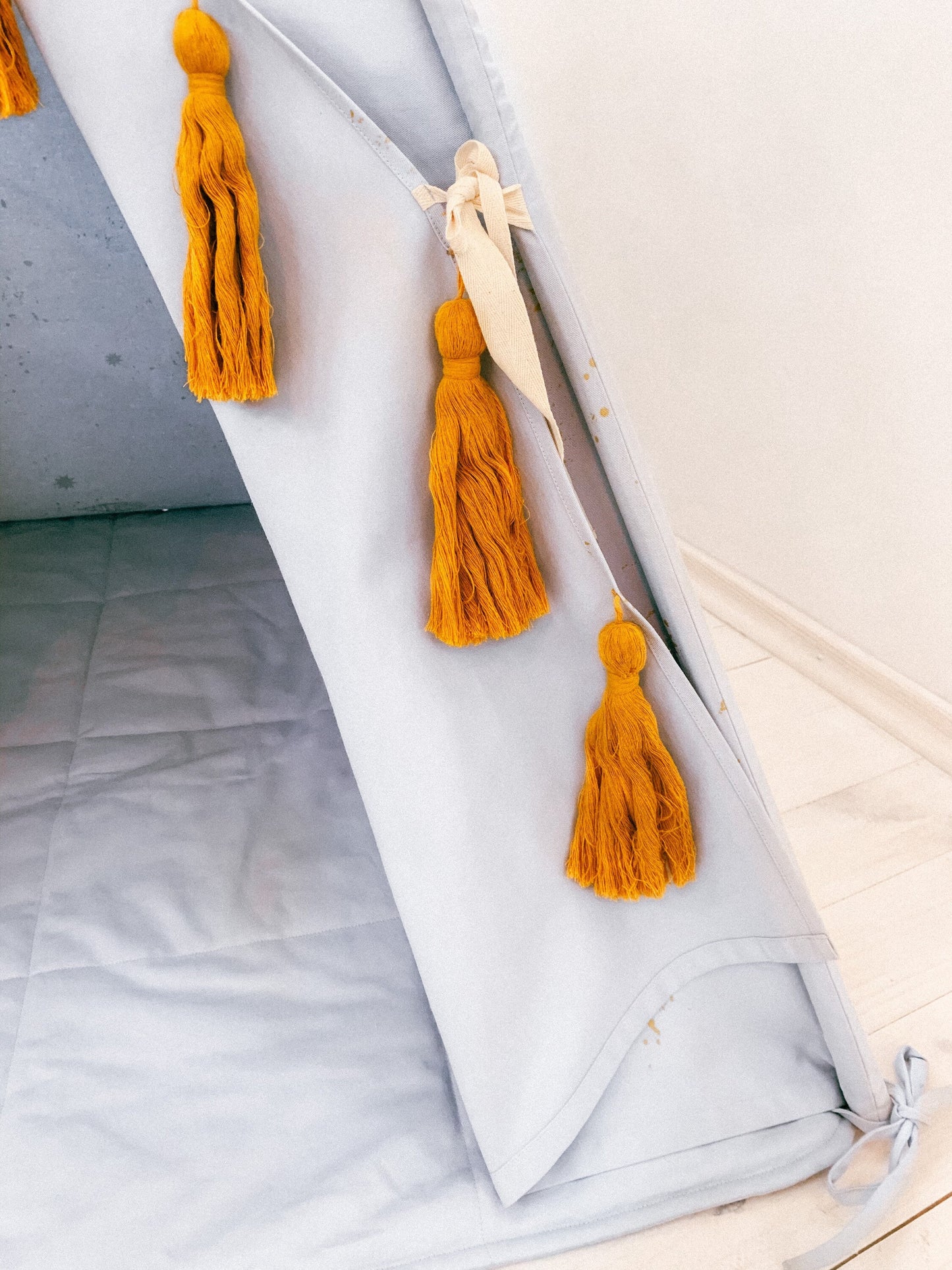 Light gray teepee with golden stars and mustards macrame tassels - first birthday